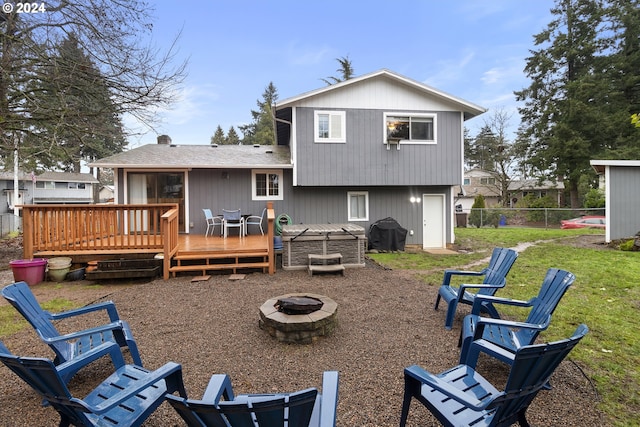 back of property with a fire pit and a deck