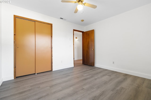 unfurnished bedroom with a closet, light wood-type flooring, and ceiling fan