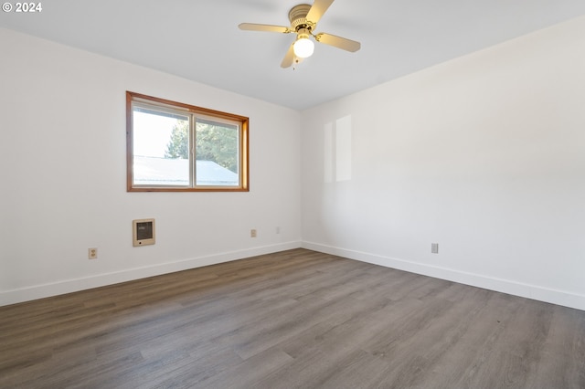 unfurnished room with wood-type flooring, heating unit, and ceiling fan