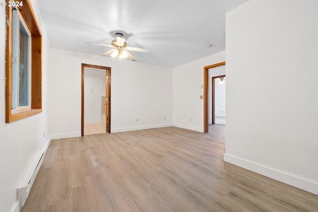 spare room with baseboard heating, light wood-type flooring, and ceiling fan