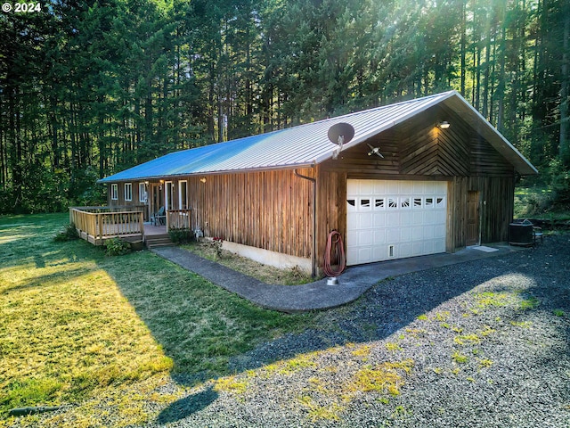 42 Fellers Rd, Carson, WA 98610 - view of front facade with central AC, a detached garage, metal roof, a view of trees, and a front lawn