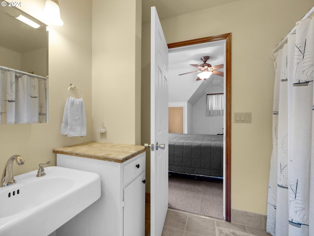 bathroom with ceiling fan, tile flooring, vaulted ceiling, and sink