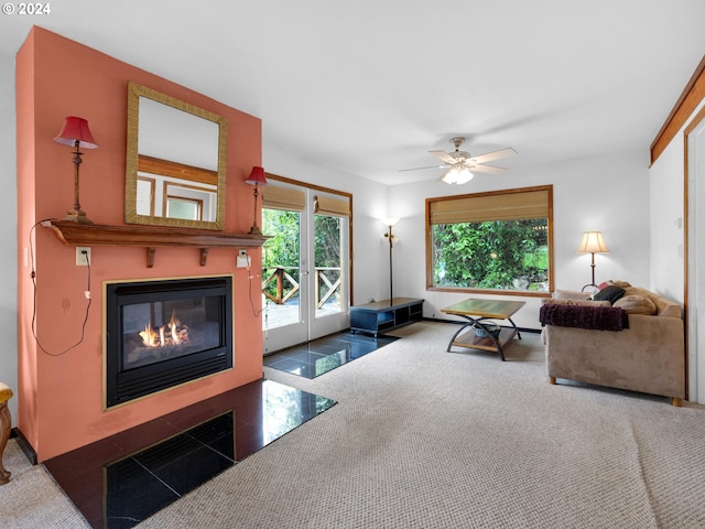 tiled living room with ceiling fan and a large fireplace