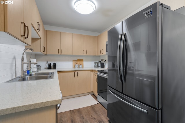 kitchen with backsplash, dark hardwood / wood-style flooring, sink, appliances with stainless steel finishes, and light brown cabinets