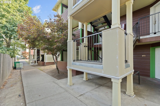 view of side of property with a balcony and central air condition unit