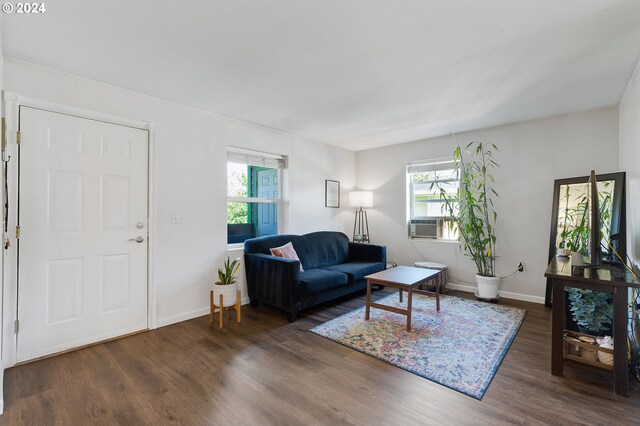 living room featuring a wealth of natural light, cooling unit, and dark hardwood / wood-style floors