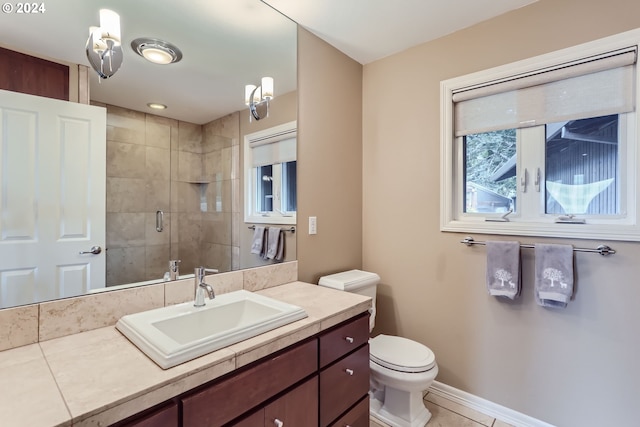 bathroom with toilet, vanity, tile patterned floors, and walk in shower