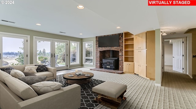 living room featuring carpet floors, french doors, and a wood stove