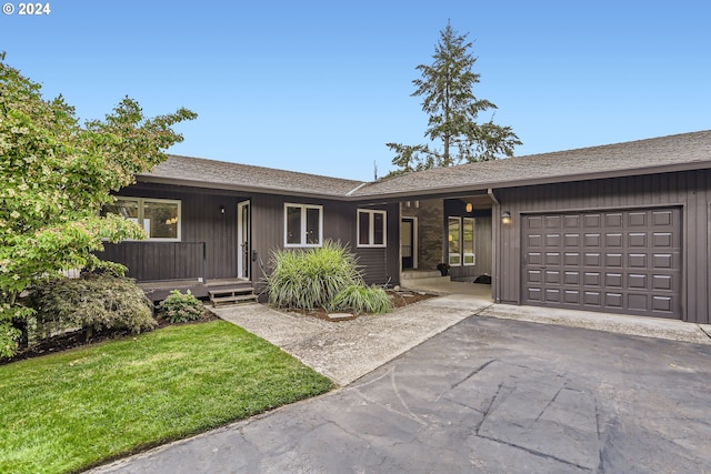 single story home with a garage and a front yard