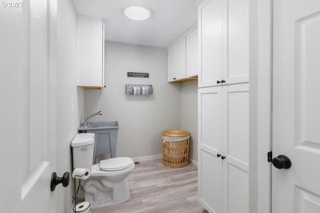 bathroom featuring wood-type flooring and toilet