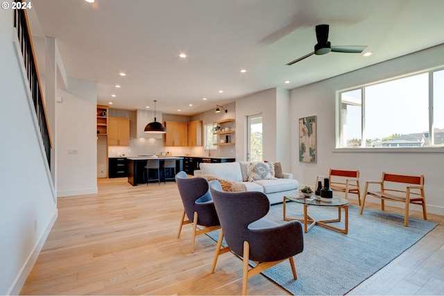 living area featuring a ceiling fan, recessed lighting, light wood-type flooring, and baseboards