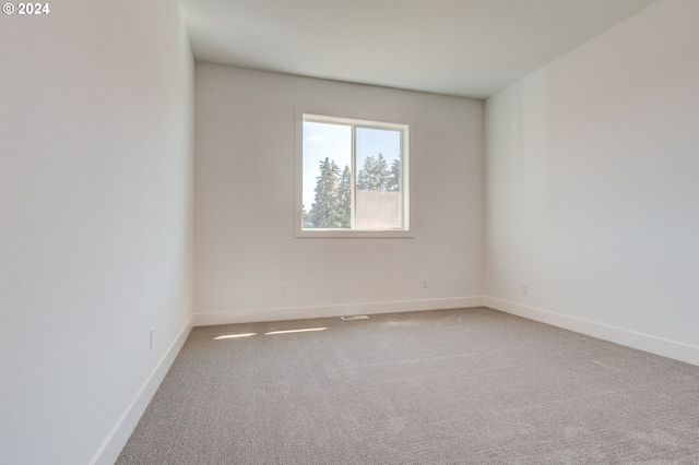 carpeted spare room with baseboards