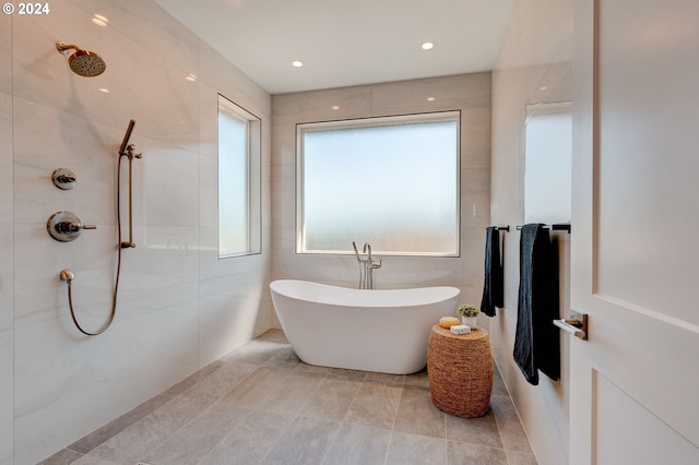 full bath featuring a soaking tub, tile walls, and a tile shower