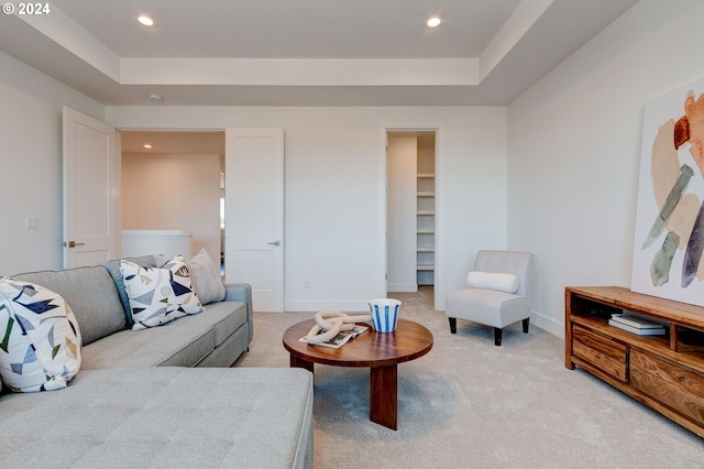 living room featuring light carpet, recessed lighting, and a tray ceiling