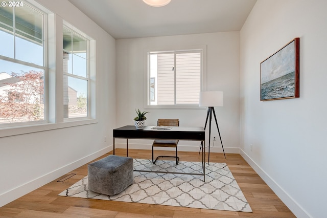 office space with visible vents, light wood-type flooring, and baseboards