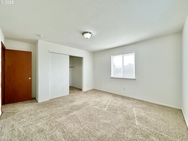 unfurnished bedroom featuring carpet, a closet, and a textured ceiling