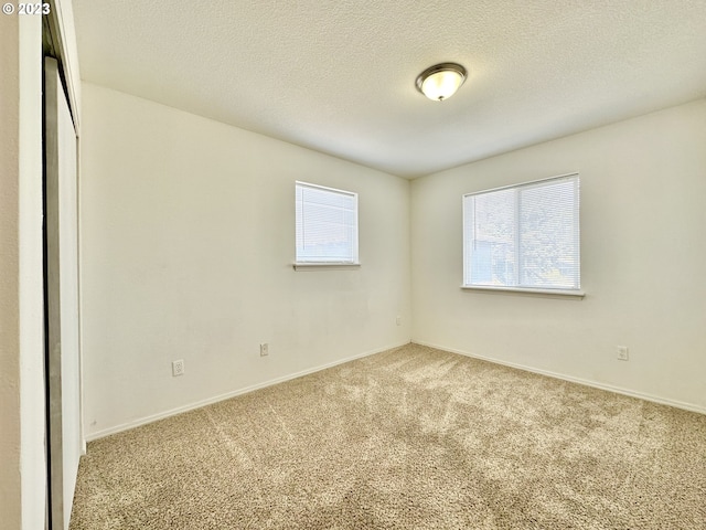 carpeted spare room with a textured ceiling