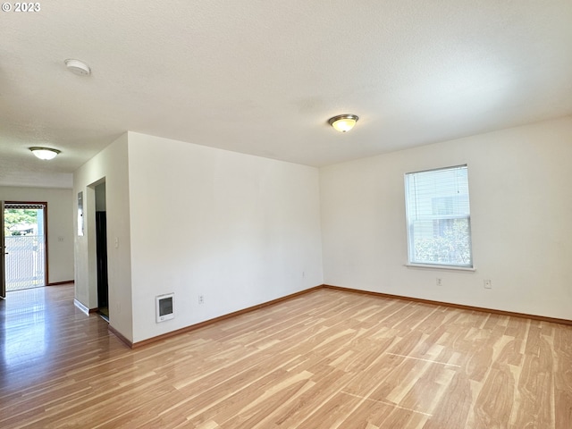 empty room featuring light hardwood / wood-style floors and a textured ceiling