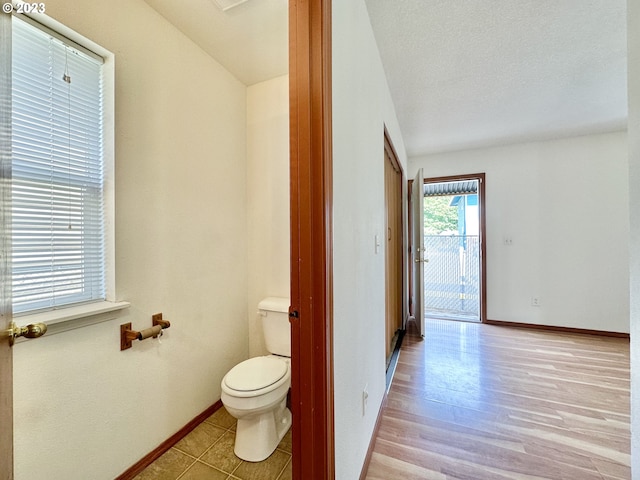 bathroom featuring hardwood / wood-style flooring, toilet, and a textured ceiling