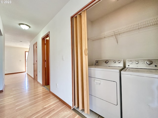 clothes washing area featuring washer and dryer and light wood-type flooring