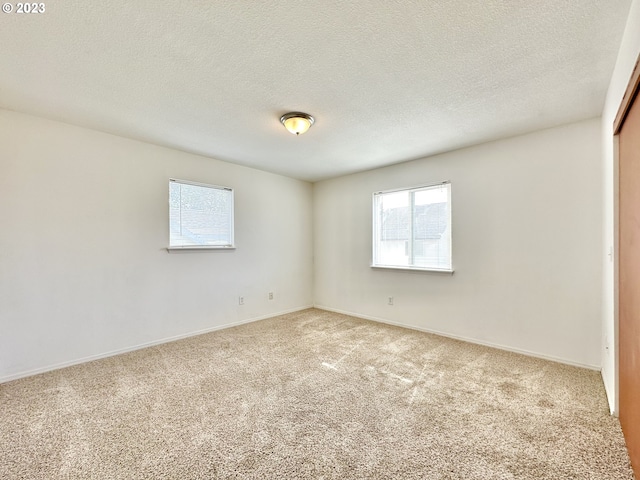 carpeted spare room featuring a textured ceiling