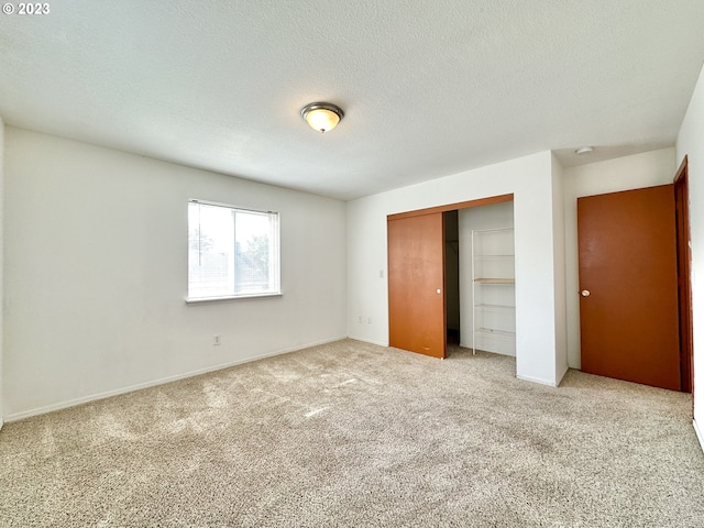 unfurnished bedroom with a closet, carpet, and a textured ceiling