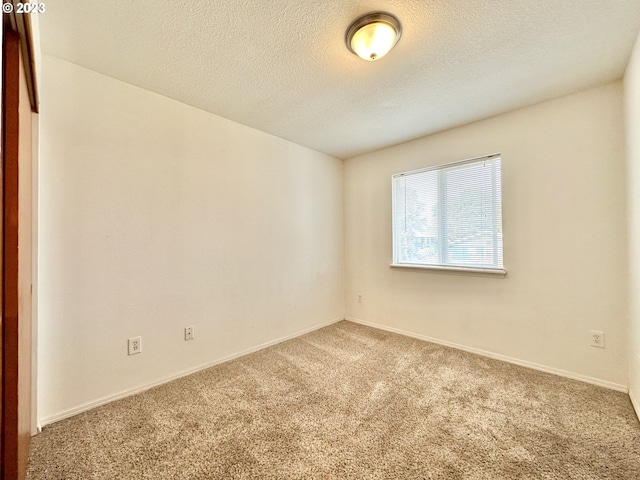 carpeted spare room with a textured ceiling