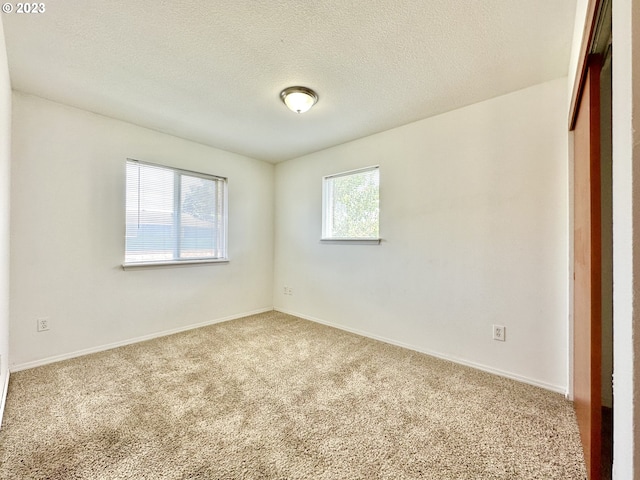 empty room with a textured ceiling and carpet floors