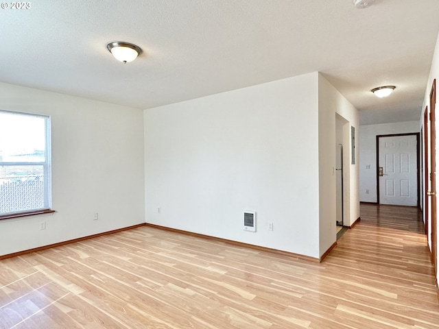 empty room featuring light hardwood / wood-style flooring and a textured ceiling