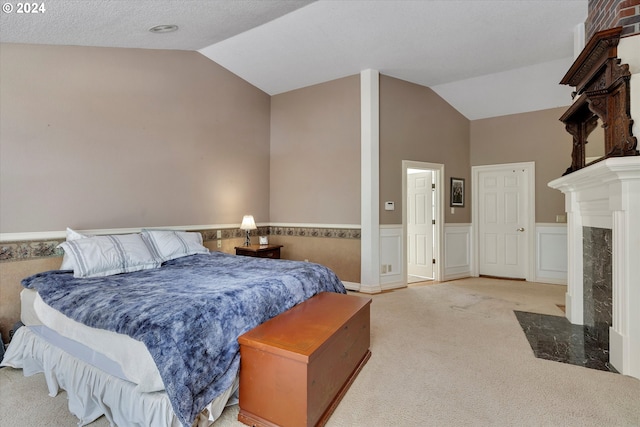 carpeted bedroom with a premium fireplace and lofted ceiling