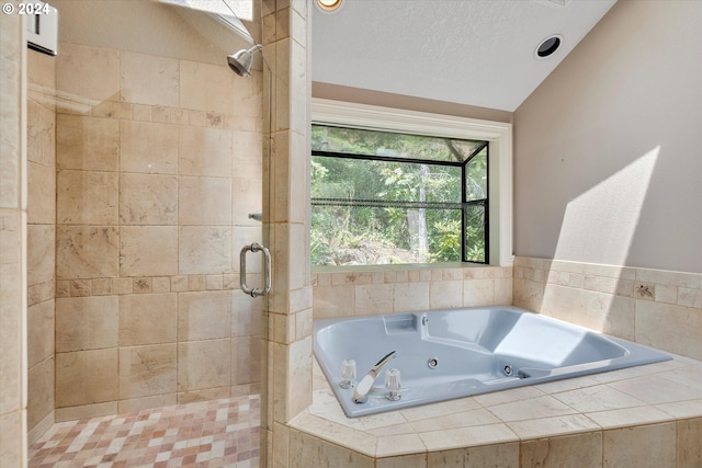 bathroom with independent shower and bath, vaulted ceiling, and a textured ceiling