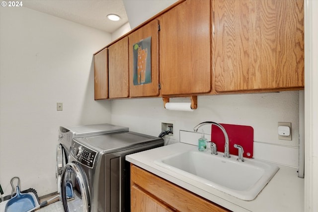 laundry room featuring cabinets, sink, and washer and clothes dryer