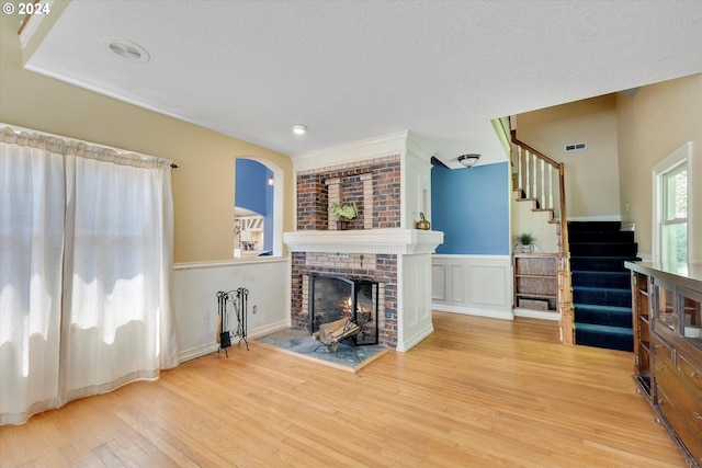 living room featuring hardwood / wood-style floors, a fireplace, and a textured ceiling