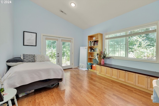 bedroom with vaulted ceiling, multiple windows, light hardwood / wood-style floors, access to outside, and french doors