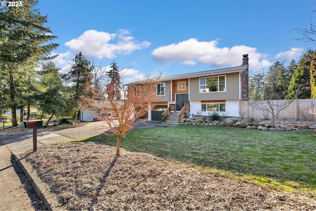 split foyer home with a garage and a front yard