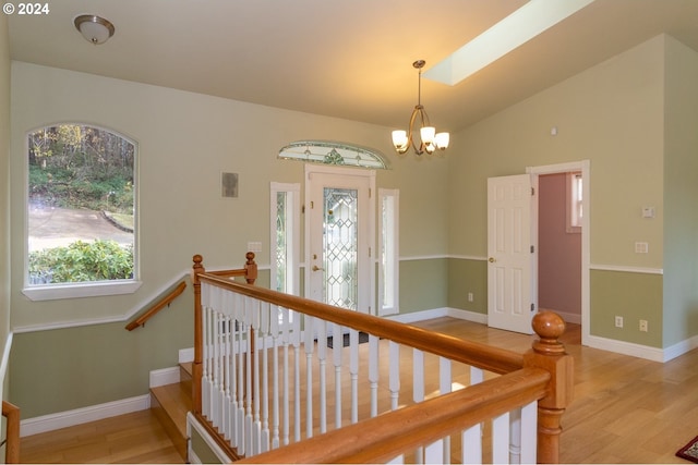 88378 Collard Lake Rd, Florence, OR 97439 - staircase with wood finished floors, baseboards, a chandelier, and vaulted ceiling