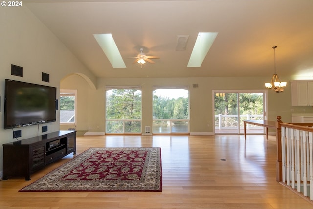 living room featuring a healthy amount of sunlight, ceiling fan with notable chandelier, and light hardwood / wood-style floors