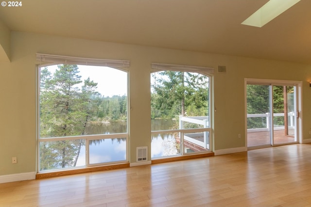 doorway with a skylight, a healthy amount of sunlight, and a water view