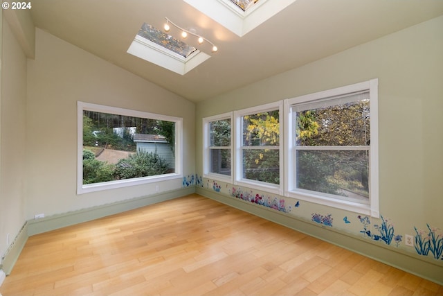 88378 Collard Lake Rd, Florence, OR 97439 - spare room featuring a skylight, vaulted ceiling, wood finished floors, and baseboards