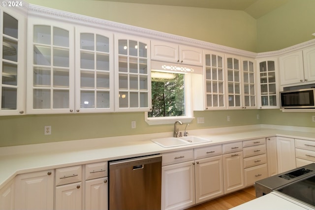 88378 Collard Lake Rd, Florence, OR 97439 - kitchen featuring appliances with stainless steel finishes, a sink, white cabinetry, glass insert cabinets, and light countertops