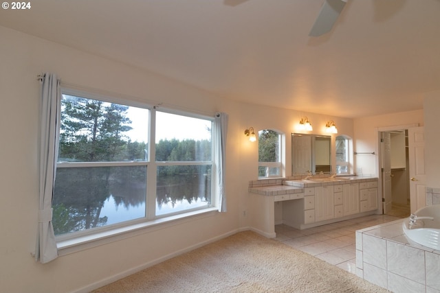 bathroom featuring tile patterned floors, a water view, vanity, and a bath