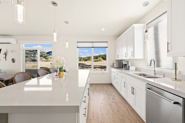 kitchen featuring a kitchen island, light wood-style floors, a wall mounted AC, a sink, and dishwasher