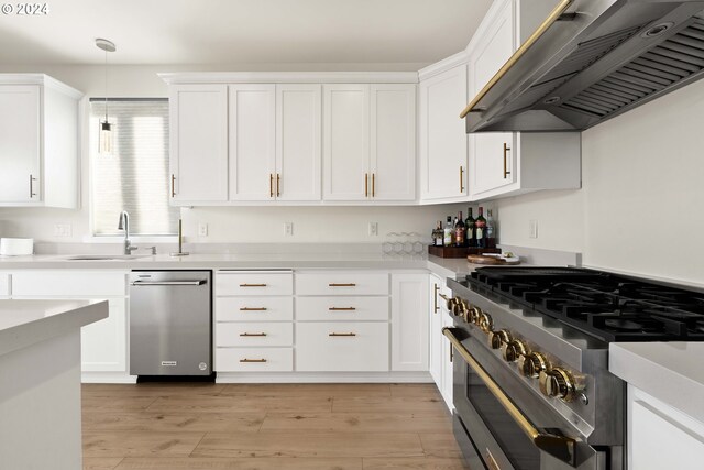 kitchen featuring appliances with stainless steel finishes, light countertops, white cabinetry, decorative light fixtures, and under cabinet range hood