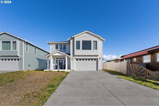 traditional home featuring an attached garage, fence, and driveway