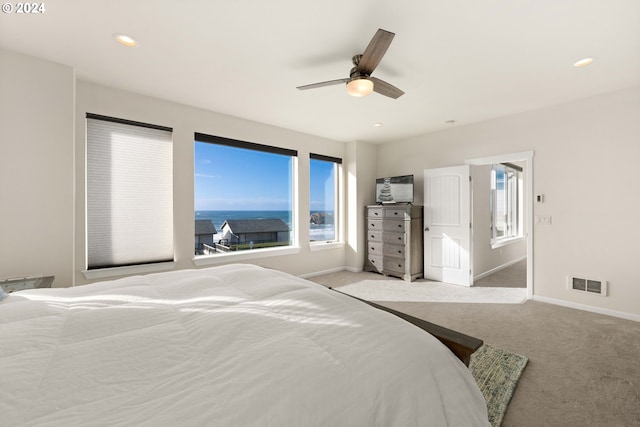 carpeted bedroom with a ceiling fan, baseboards, visible vents, and multiple windows