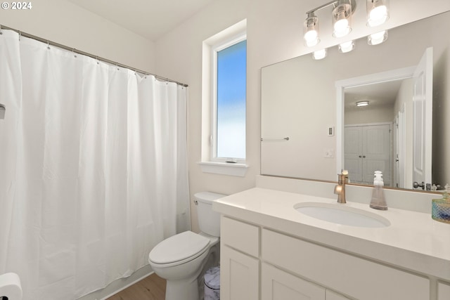 bathroom featuring toilet, wood finished floors, and vanity