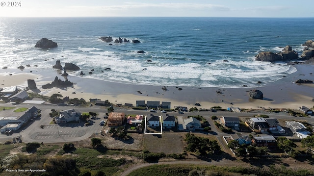 drone / aerial view featuring a water view and a view of the beach