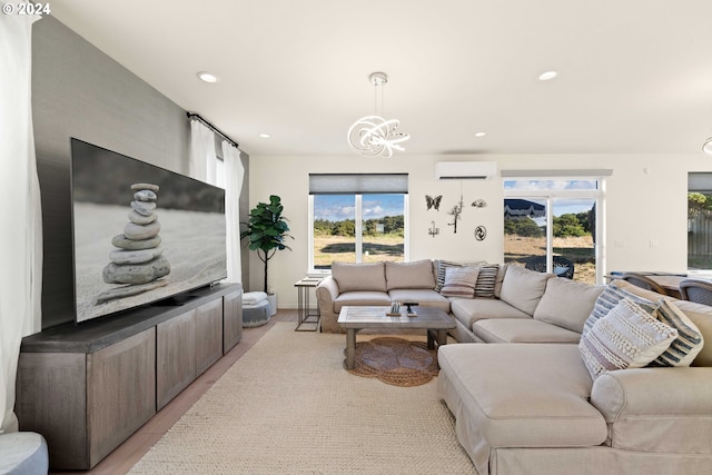 living room with an inviting chandelier, recessed lighting, light wood-style flooring, and a wall unit AC
