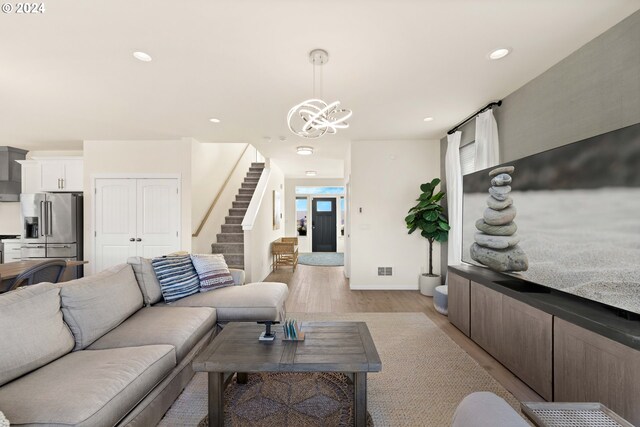 living room with light wood-style floors, a chandelier, stairs, recessed lighting, and visible vents