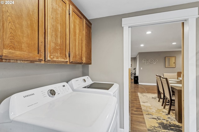 laundry area with washing machine and dryer and hardwood / wood-style floors